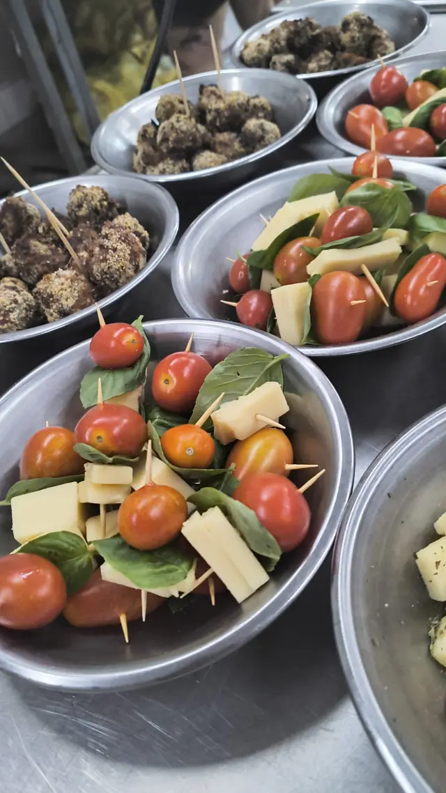 Brochetas caprese y ensaladas en fuentes