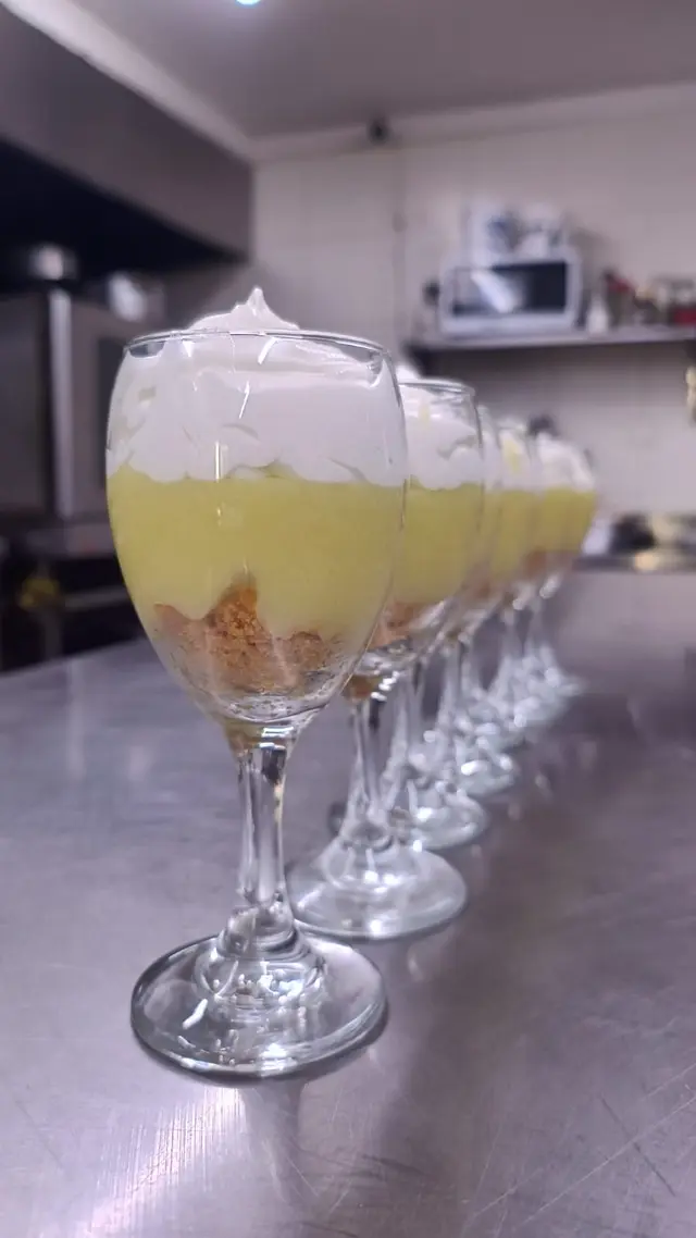 Hilera de copas con postre cremoso en la cocina
